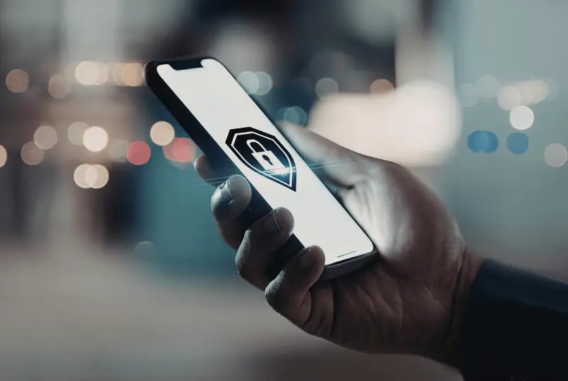 Hand holding a smartphone with a security lock icon on the screen for mobile access control